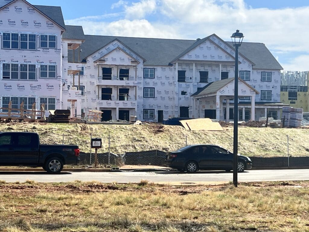 construction of community building, view of road with parked cars